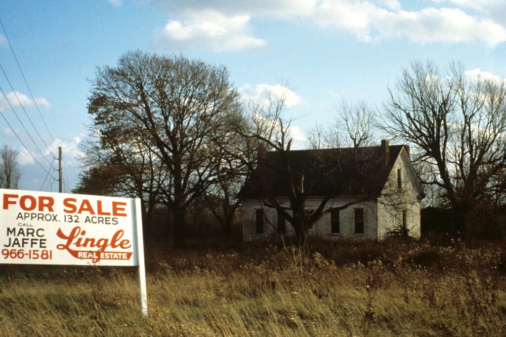 House with for-sale sign representing real estate tax