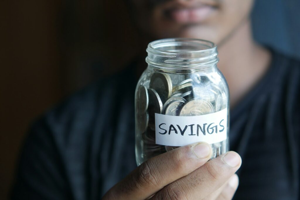A man holding a jar with a savings label