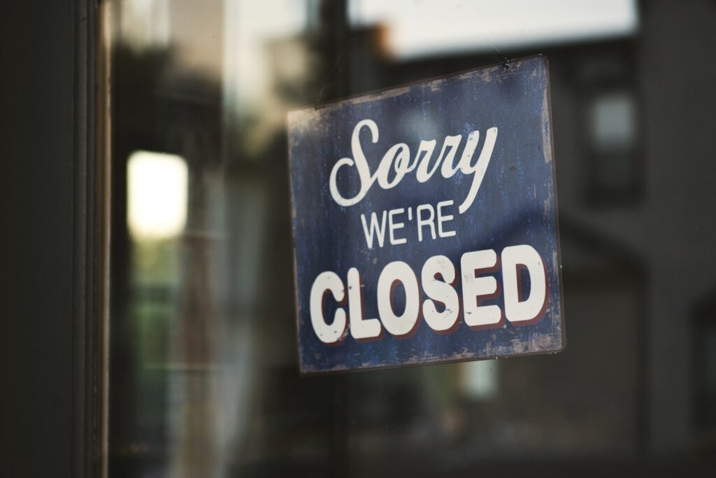 Sorry we're closed sign hanging on a glass door