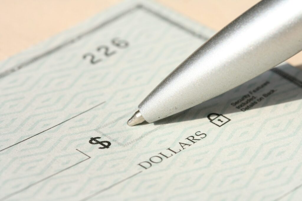 Hiring Your First Employee in the US: A Payroll Withholding and Payroll Tax Checklist for Japanese Employers Pen poised over a check, ready to write