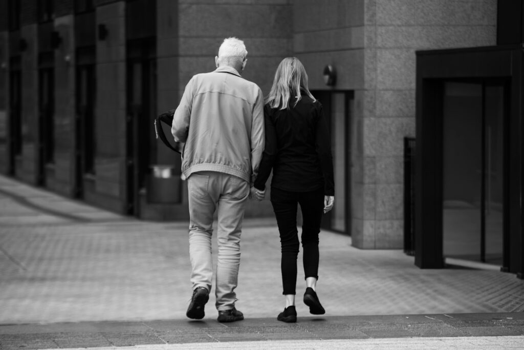 米国ソーシャルセキュリティ年金を日本で受け取る:海外受給の手続き・Form SSA-7162・税務 Two people walking hand in hand down a city street in black and white