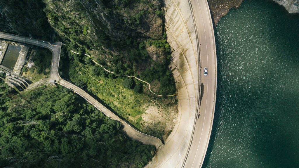 Aerial view of a white car on a forest road