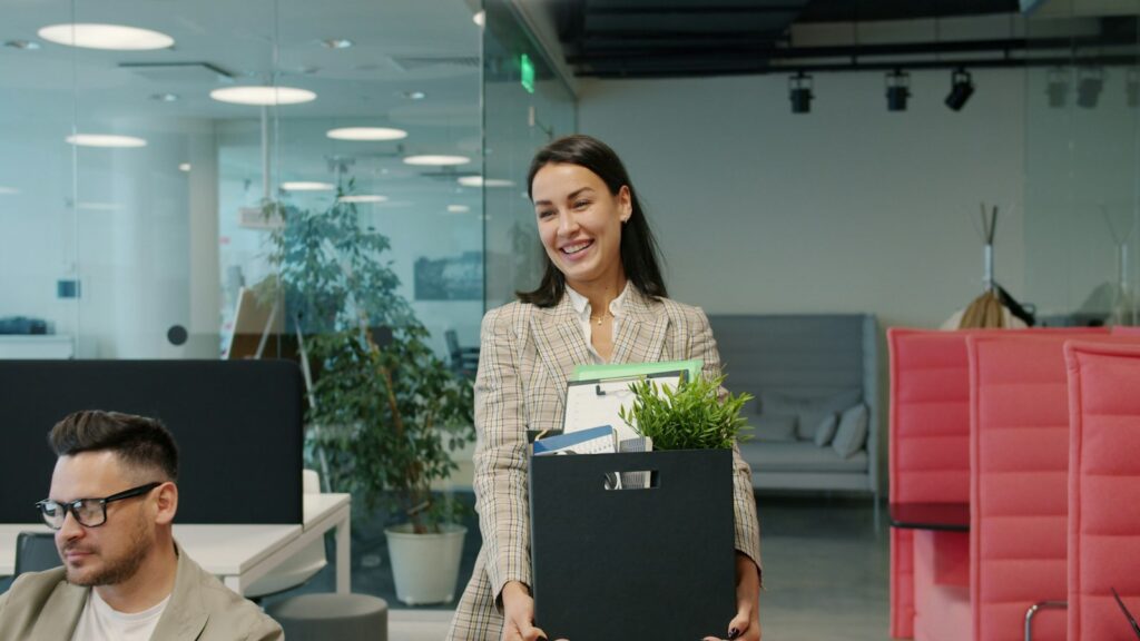 Employee carrying a box of belongings out of an office